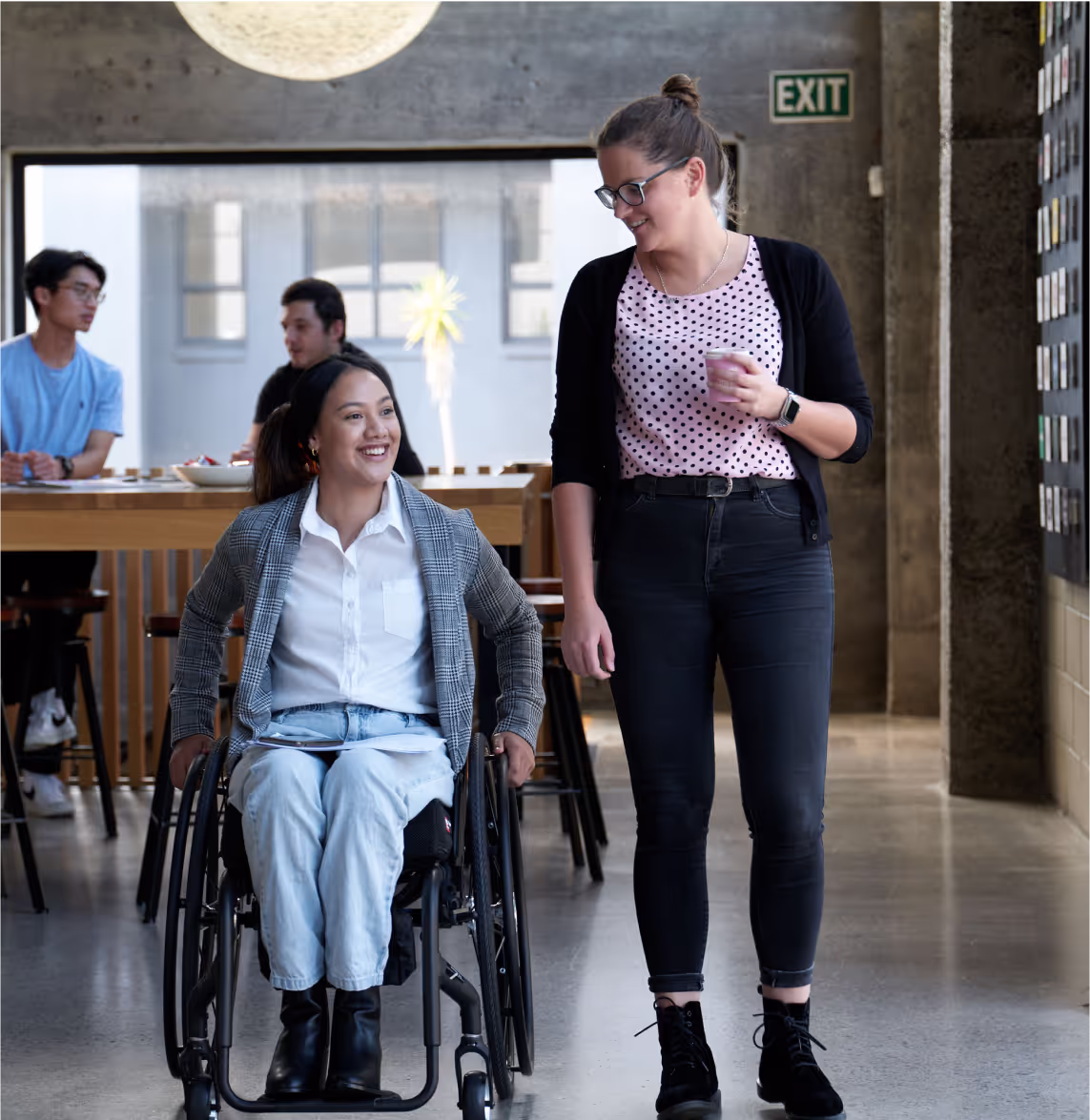 A wheelchair user and her colleague in a cafe. Credit: Medifab.