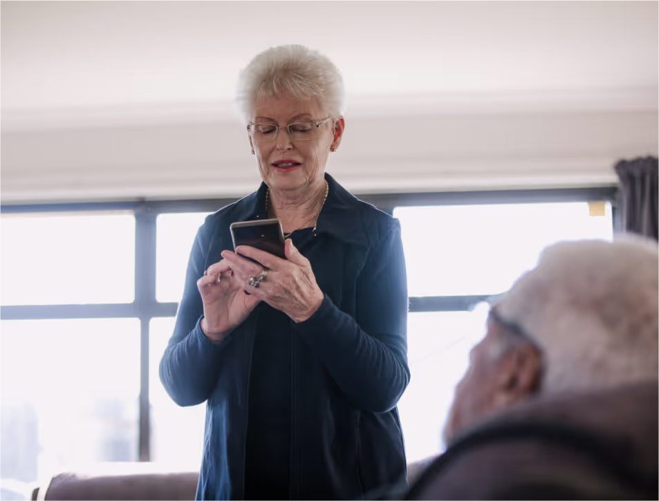 An older woman using her smartphone at home